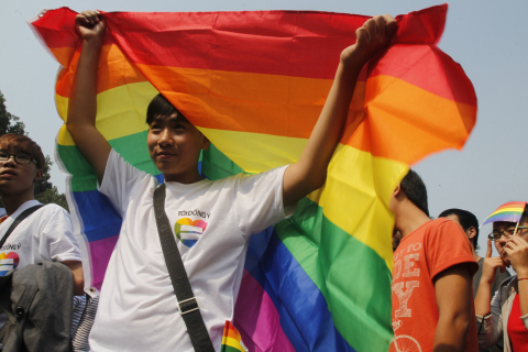 A participant holds up a rainbow flag during a LGBT event on a street in Hanoi