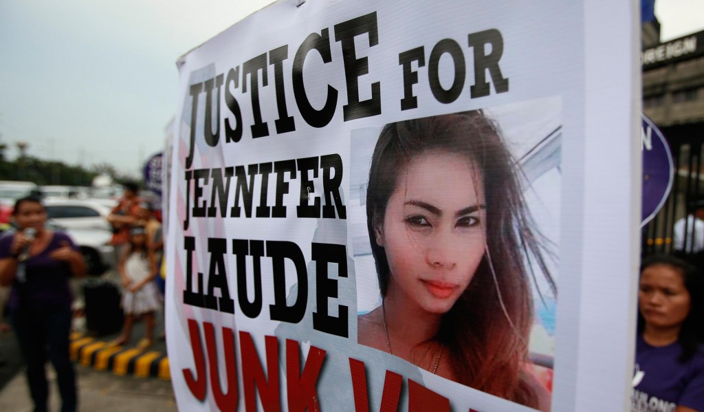  Protesters display a placard with a picture of Laude during a rally in Manila
